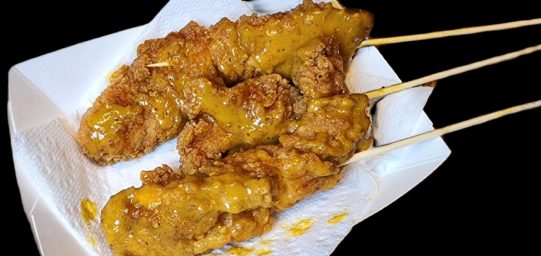 three South Carolina style mustard smothered chicken tenders with skewers.
